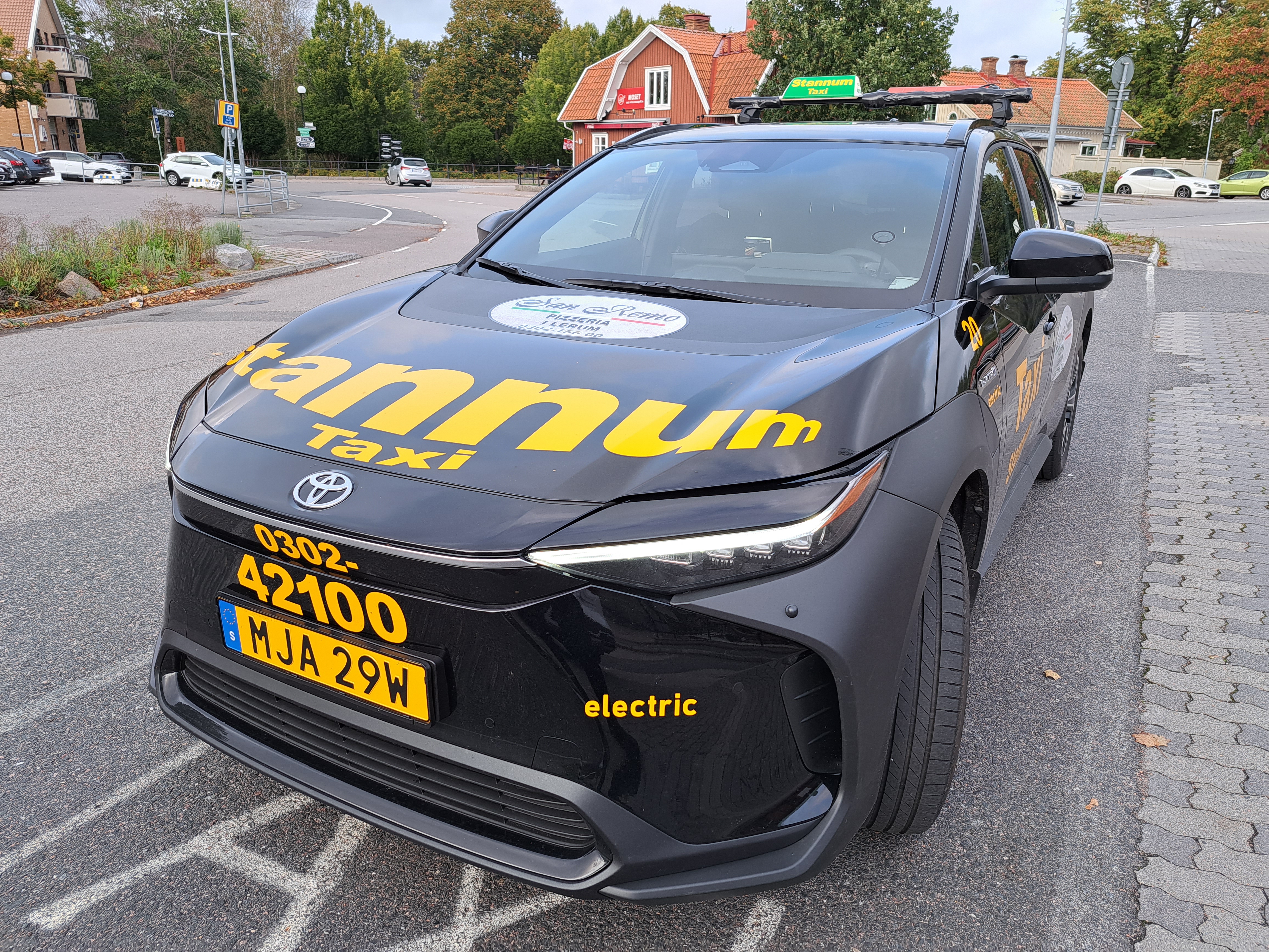 Stannum Taxibil utomhus på en gata. Hus i bakgrunden.